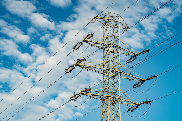 Electricity pylon and power lines against a blue sky
